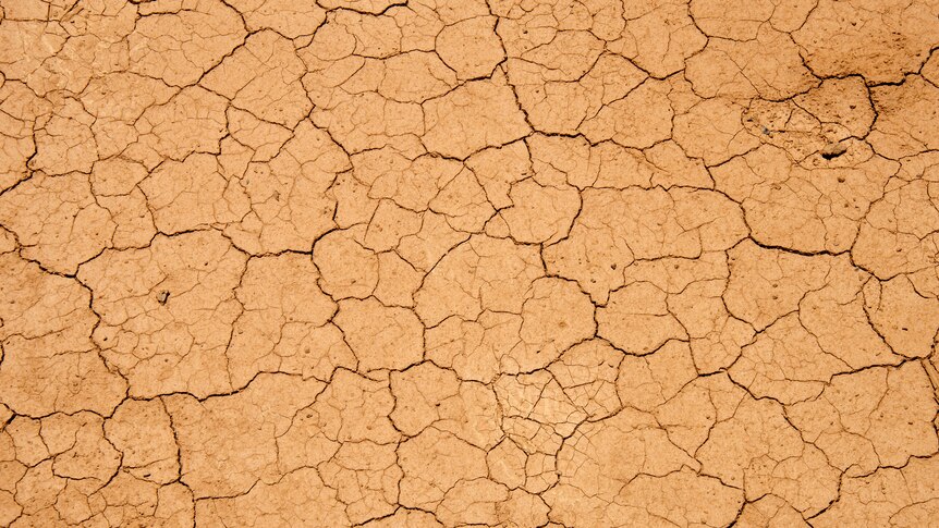 Dry, cracked red earth with the text "Drought"