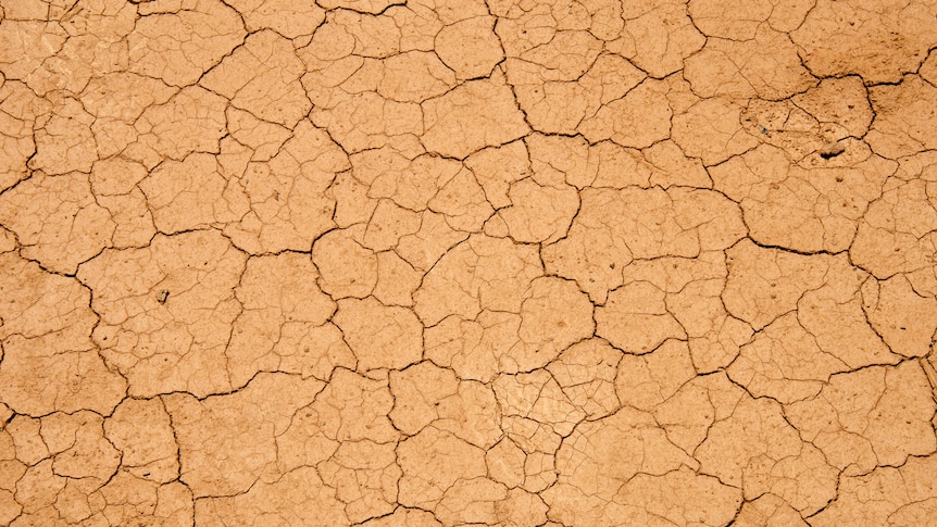 Dry, cracked red earth with the text "Drought"