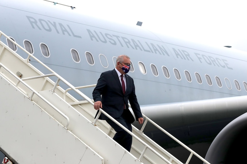 Scott Morrison exits a RAAF jet after landing in the UK.