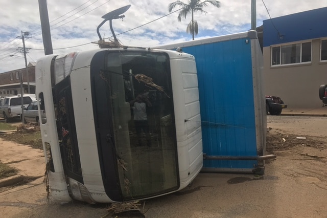 A truck is turned on its side.