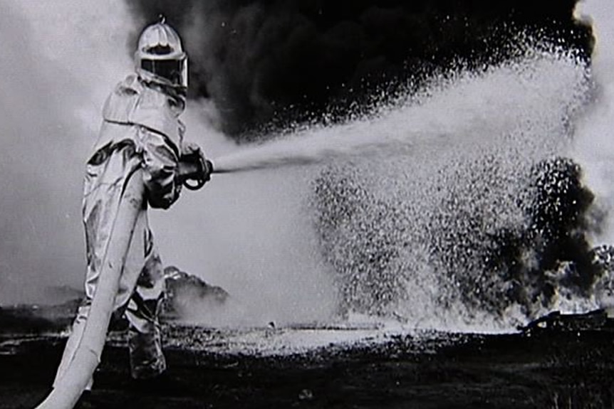 A RAAF firefighter extinguishes a blaze at a base in Australia.
