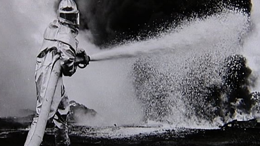 A RAAF firefighter extinguishes a blaze at a base in Australia.