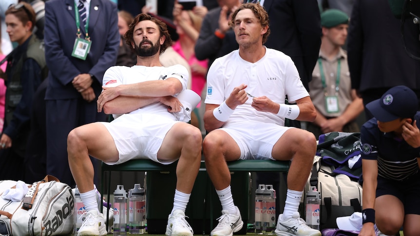 Jordan Thompson and Max Purcell sit in their chairs after losing Wimbledon men's final.