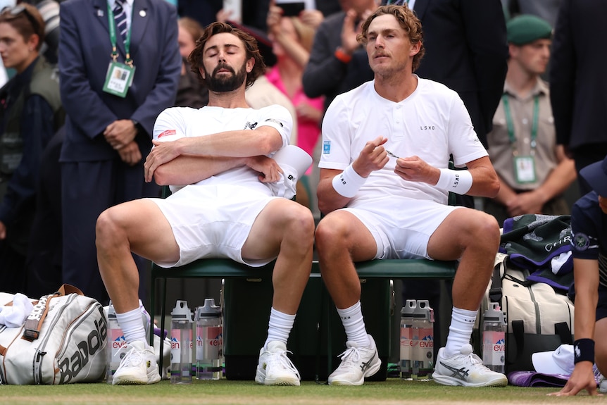 Jordan Thompson and Max Purcell sit in their chairs after losing Wimbledon men's final.