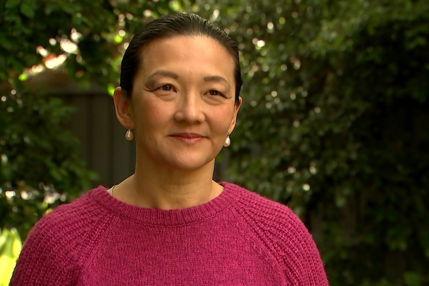 A woman with dark hair, wearing a red top.