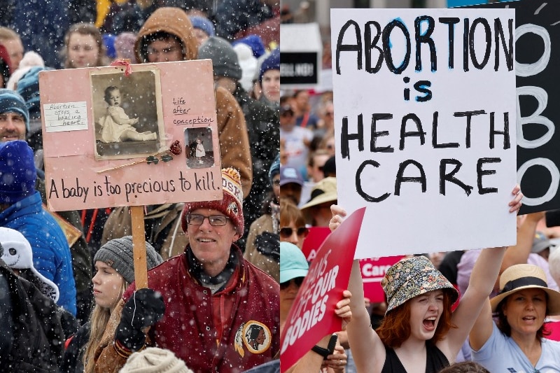 A man holds a sign 'a baby is too precious to kill'. A woman holds an 'abortion is health care' sign.