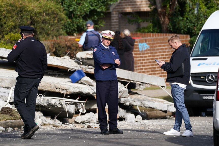 Police looking through debris at a site of an explosion