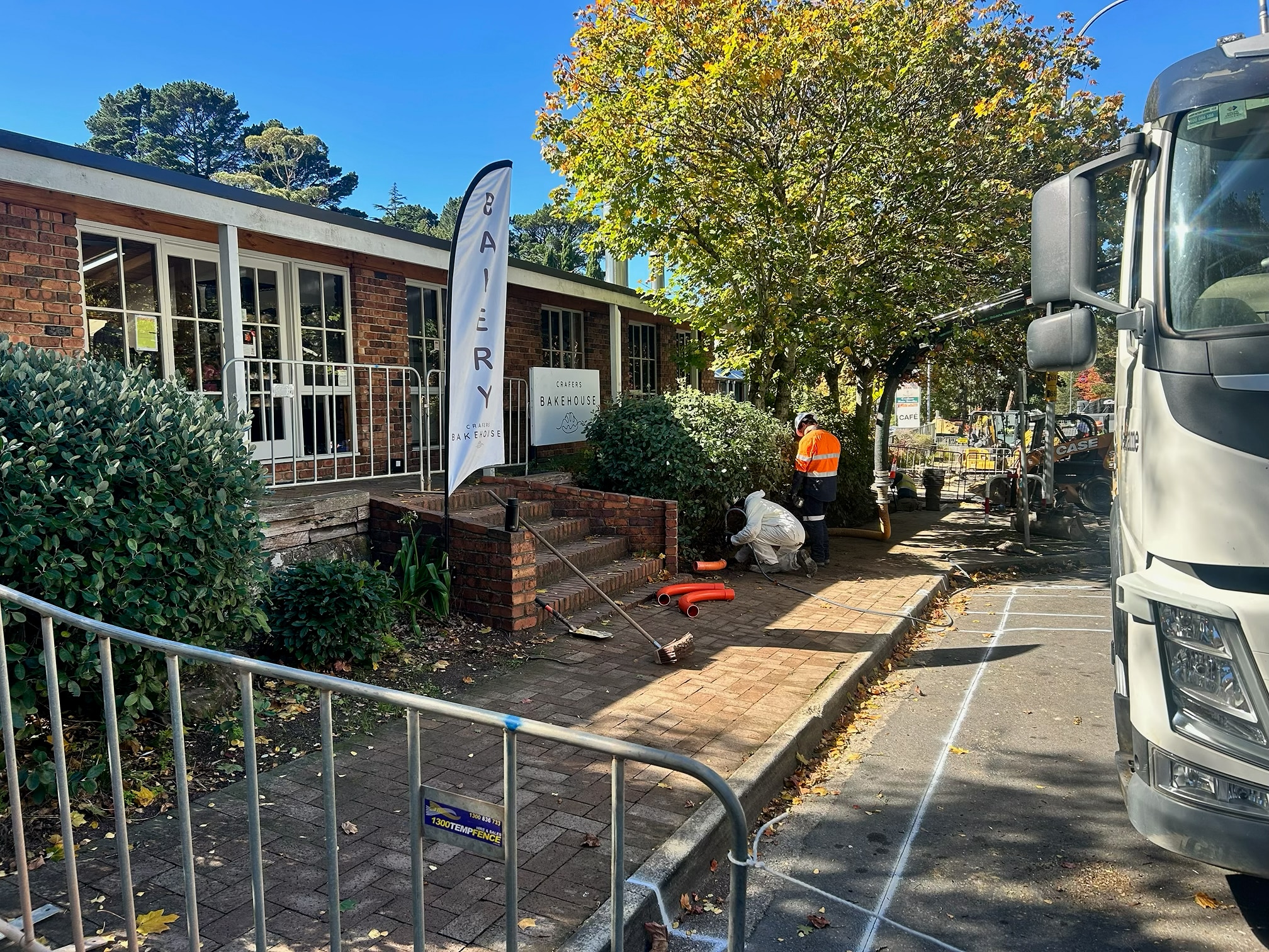 Road workers outside a bakery on a street