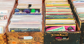 A collection of vintage vinyl held in battered wooden crates.