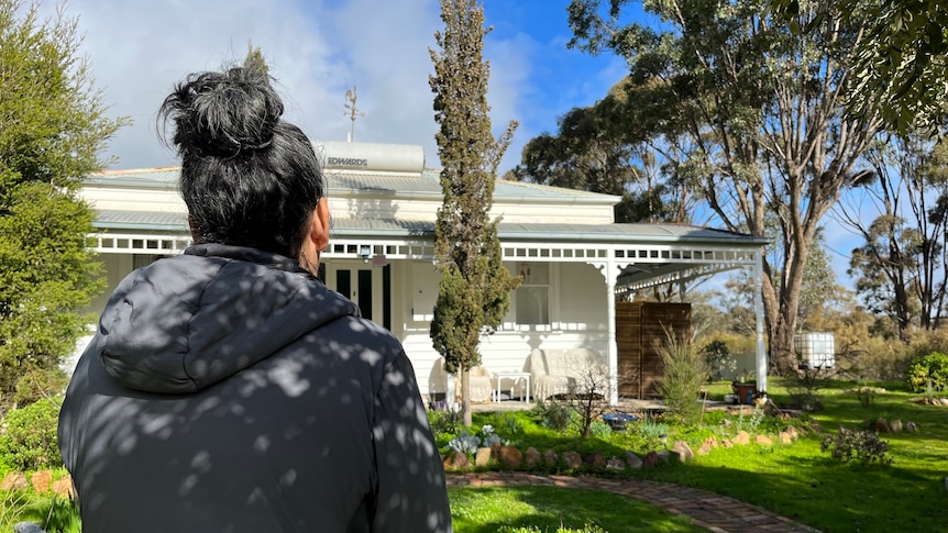 Jane stands in front of a regional home.