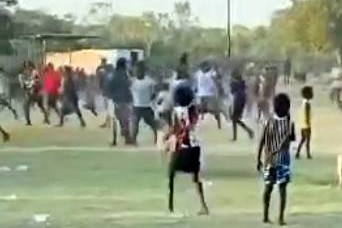 A group of spectators running on a football field