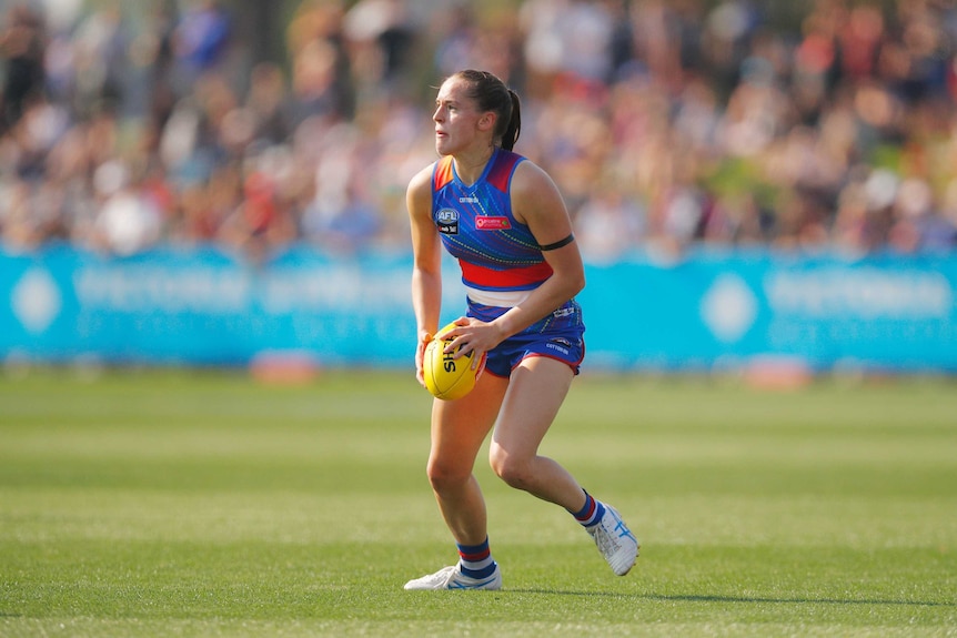 Isabel Huntington holds the ball as she prepares to kick in an AFLW match against Carlton in 2019.