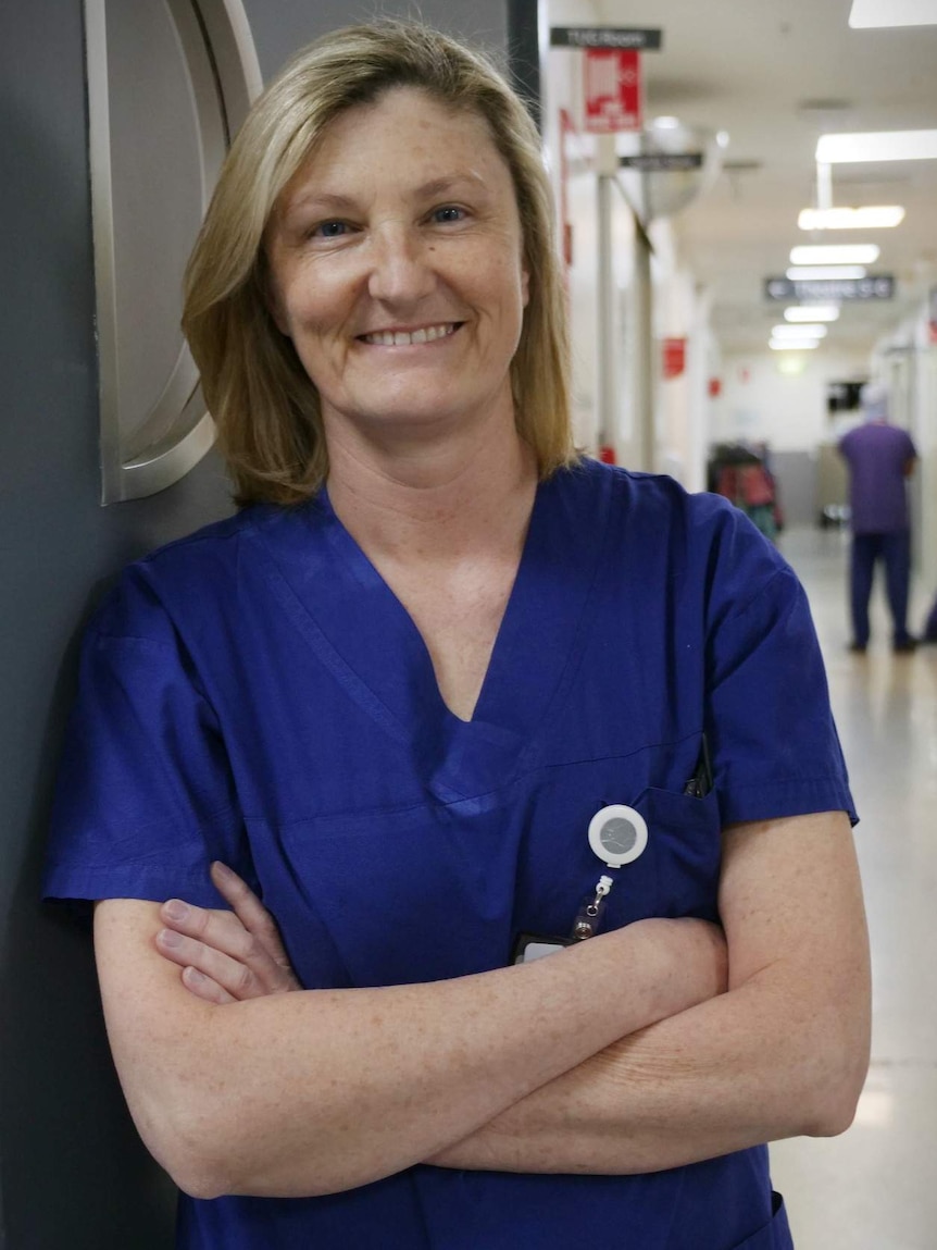 Dr Drummond, in her surgical scrubs, stands in the hallway of the hospital