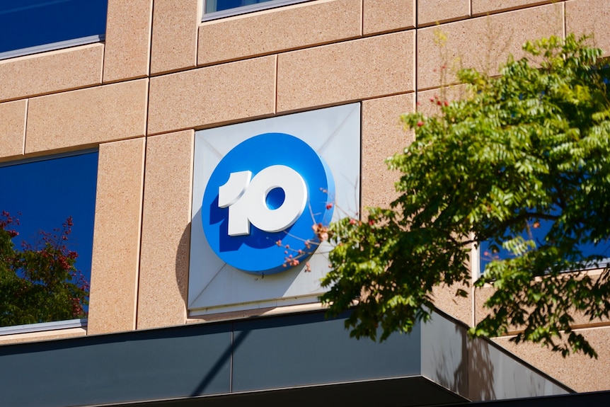 Sign of the number 10 in a blue circle on a brown wall