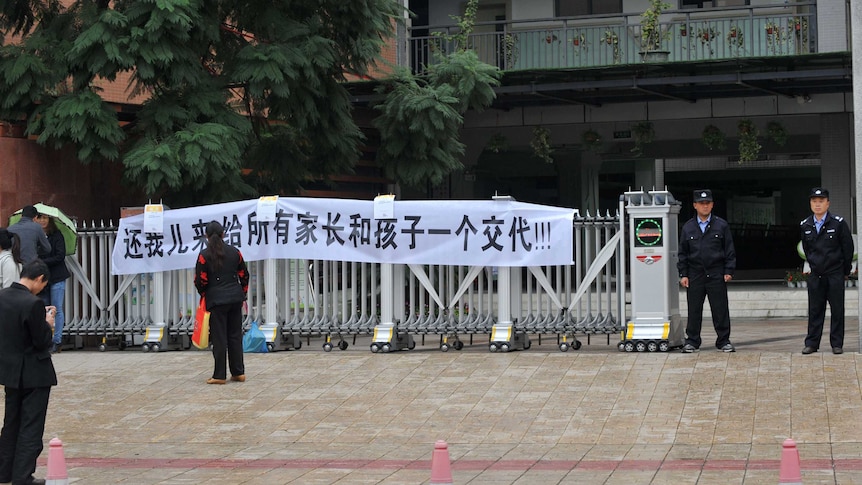 Protest sign after suicide of 10yo boy in China