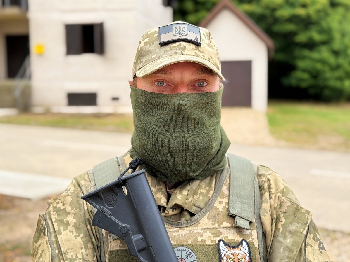 A man in military uniform looks at the camera.