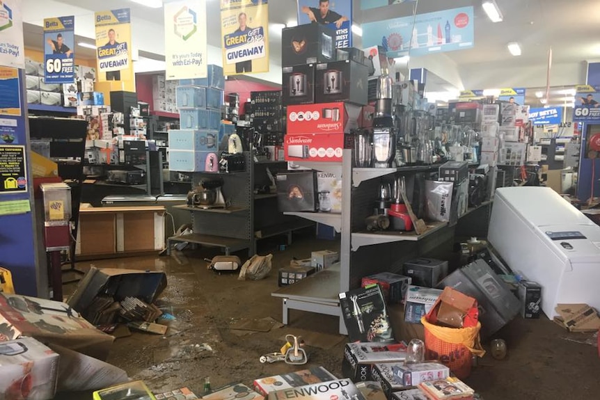Fridges, electrical equipment and kitchen appliances are strewn through the Betta electrical store as mud covers the flooring.