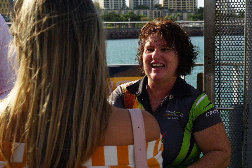 A photo of tourism operator Michelle Elliott greeting a guest boarding her boat.