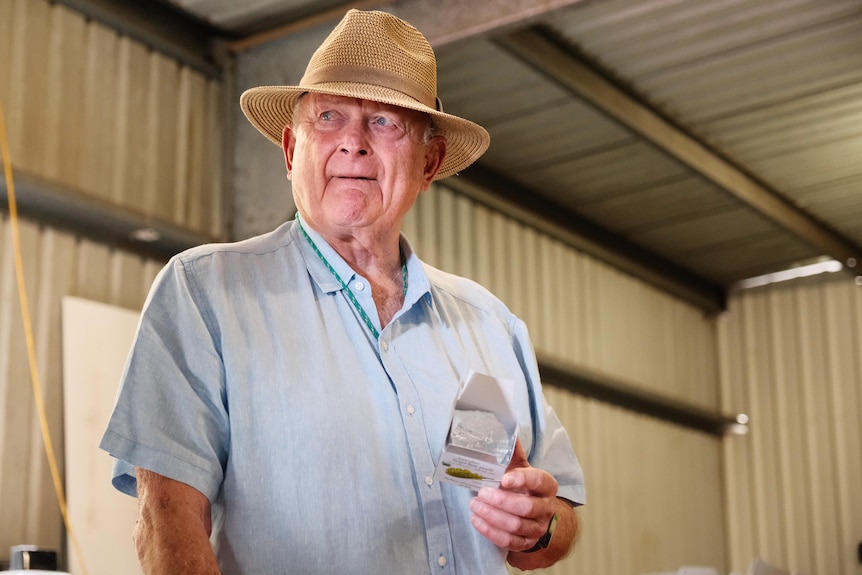 Photo of a man holding a small box.