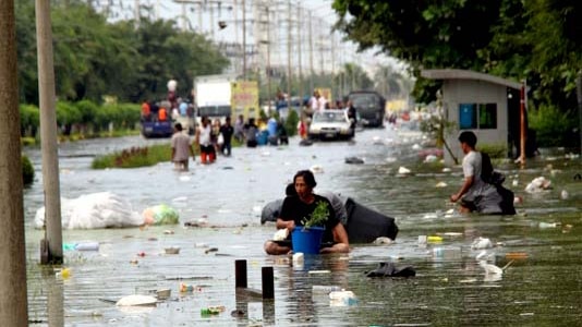 Residents of Bangkok wade through floodwater