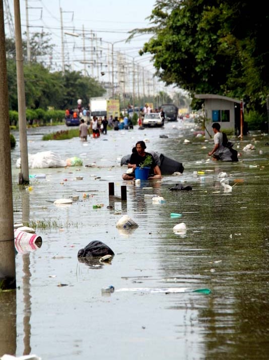 Residents of Bangkok wade through floodwater