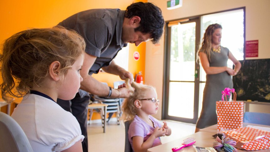 Father Adrian Terranova doing his daughter Celeste's hair while Stella waits patiently