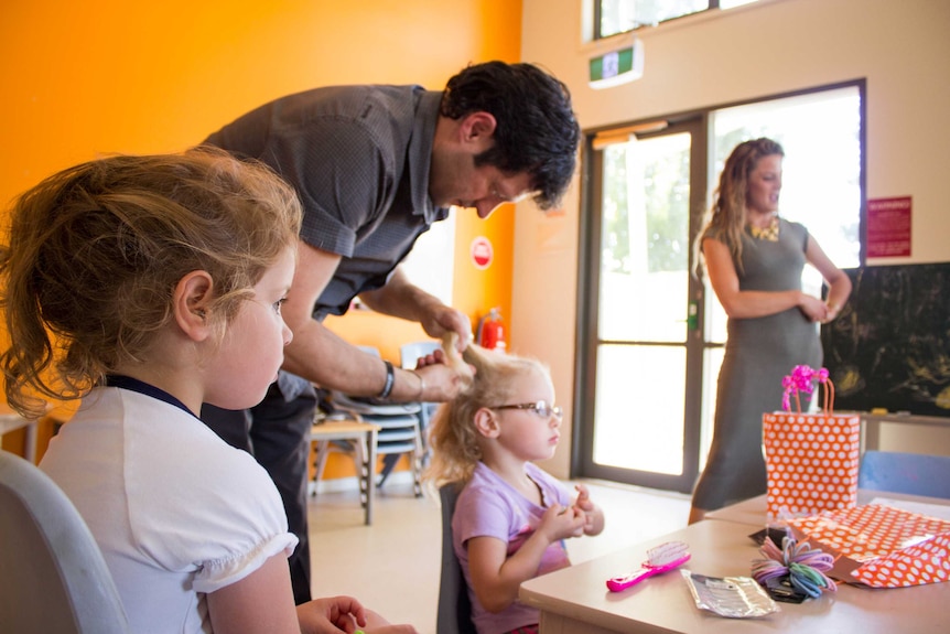 Adrian Terranova plaits his daughter Celeste's hair while Stella waits patiently