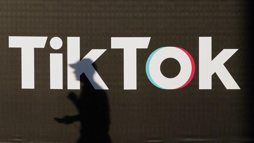 shadow of man walking in front of TikTok logo