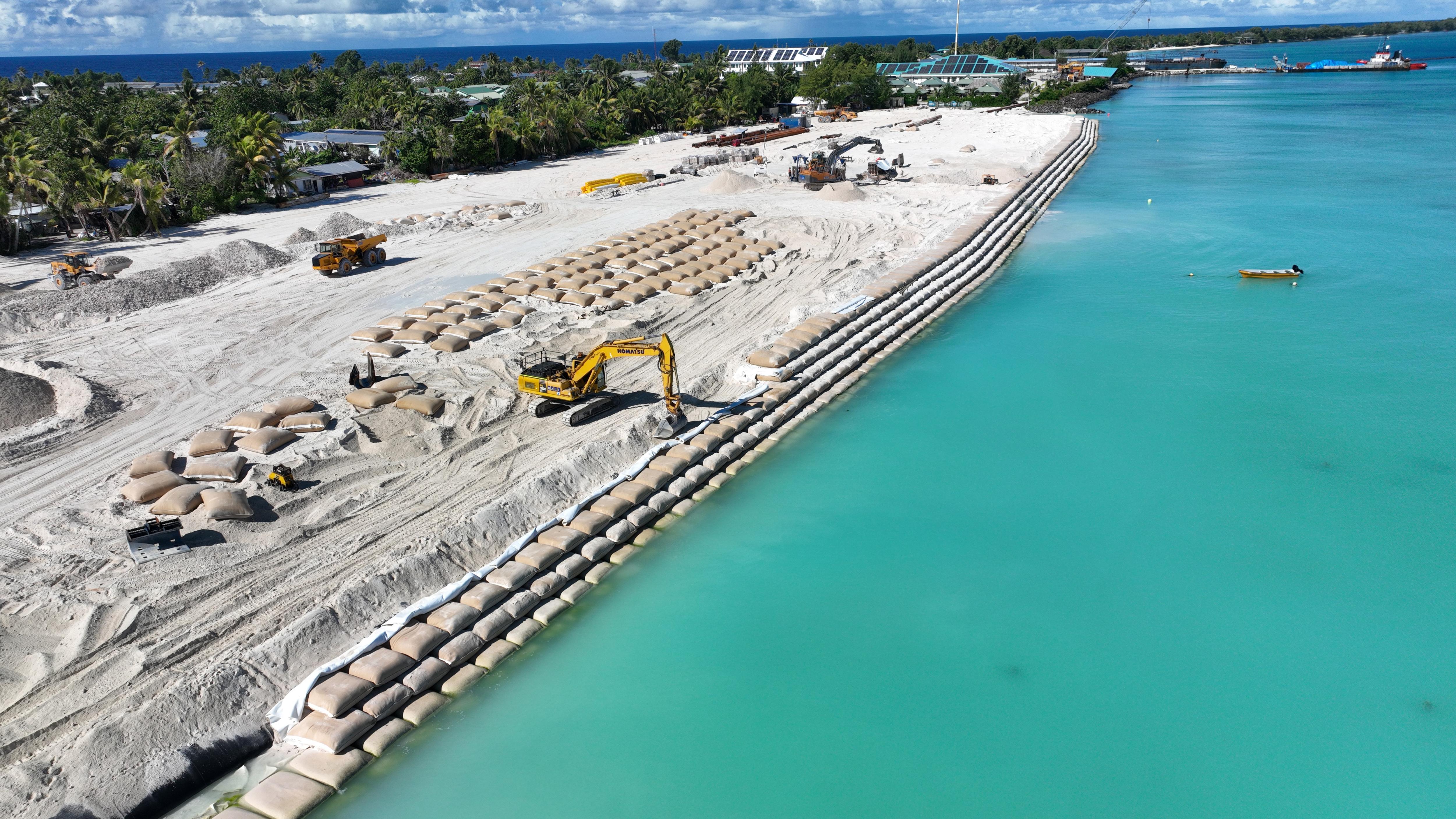 Rows of sandbags are stacked over time providing a protective barrier to newly reclaimed land areas.