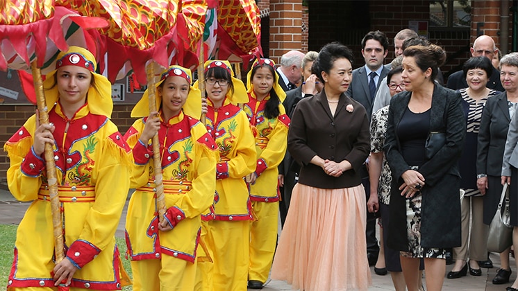 School girls dressed as a Chinese dragon alongside visiting women dignitaries.