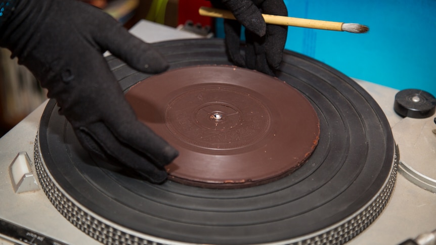 Julia Drouhin places the chocolate record on the turntable ready to play the music.