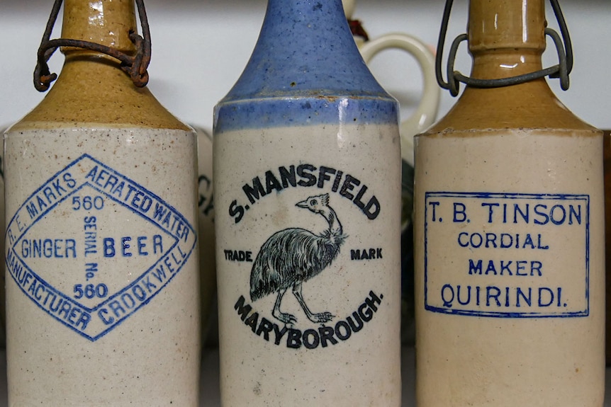 Three stone ginger bottles on a shelf