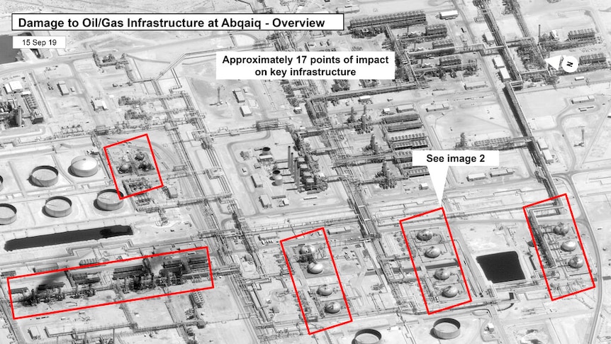 A black and white aerial image shows damage to a Saudi Arabian oil processing facility.