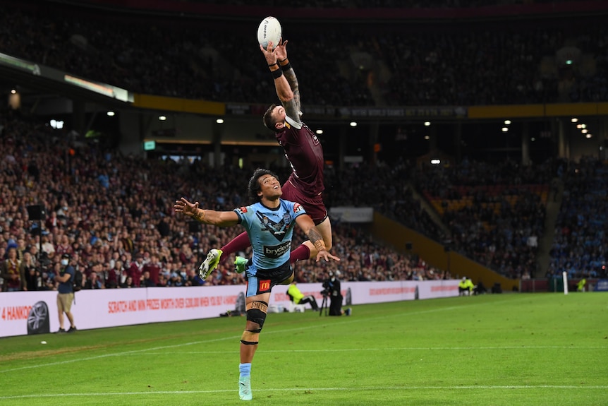 Queensland Maroons player Kyle Feldt jumps to catch a ball over NSW Blues player Brian To'o during State of Origin II.