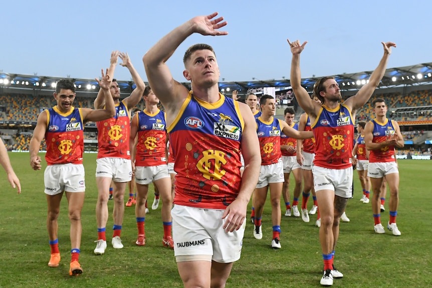 Dayne Zorko leads the Lions from the field as they wave to the crowd.