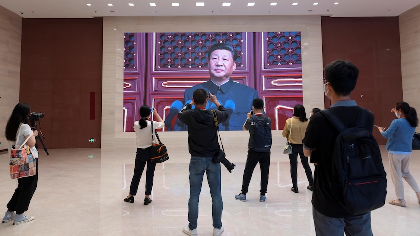 A group of people take photos of Xi Jinping. 