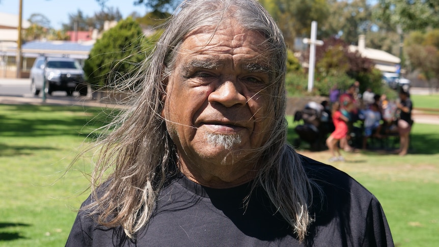 a man with long hair smiling