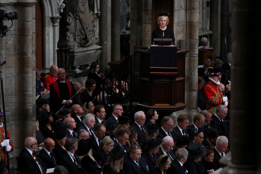 Liz Truss stands above the crowd inside Westminster Abbey for the Queen's funeral. 