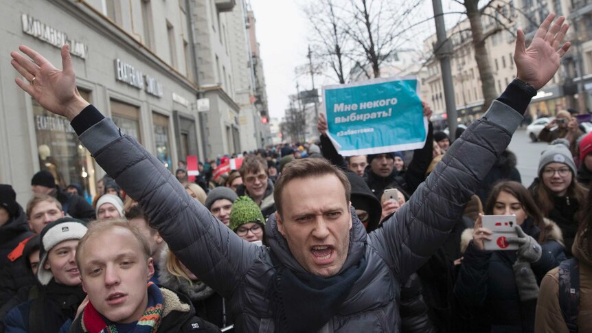 Russian opposition leader Alexei Navalny, centre, is surrounded by protesters.