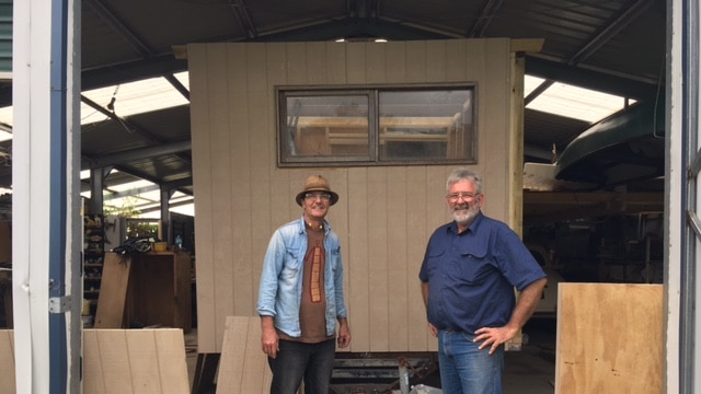 Men building a caravan in a shed