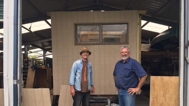 Men building a caravan in a shed