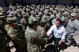 Arizona's Republican Govenor Doug Ducey shakes the hand of a troop in the middle of a crowd of Arizona National Guard soldiers