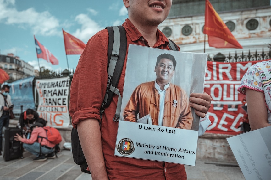 A protester holds a portrait showing Lwin Ko Latt. 