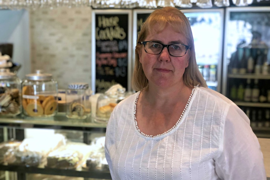 Emma Fensom, owner of Periwinkles cafe in Port MacDonnell, stands in front of her counter.