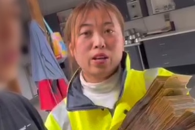 a chinese woman hold a large stack of cash