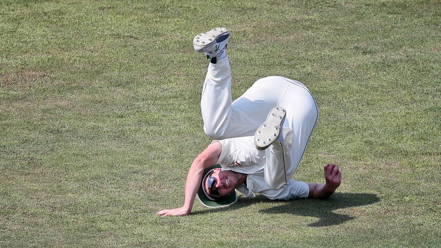 Australia's Steve O'Keefe dives to stop the ball.