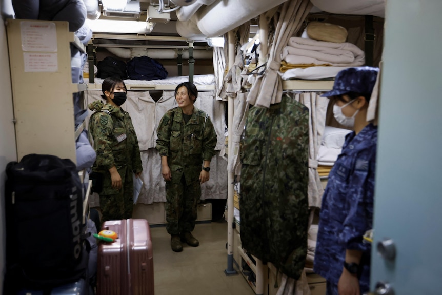Several women in military uniform in the quarters of an amphibious transport ship. 