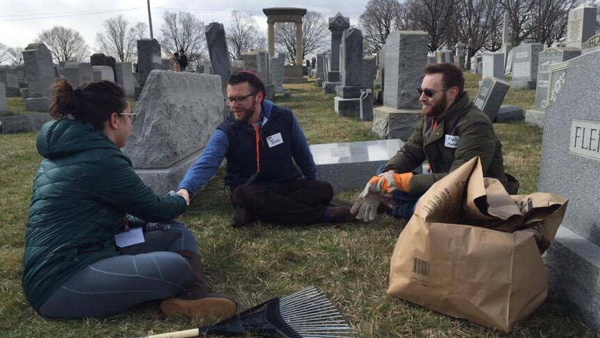 Rabbi Joel Seltzer (c) and Allen Hornblum (r) greet a volunteer helping with the clean-up.