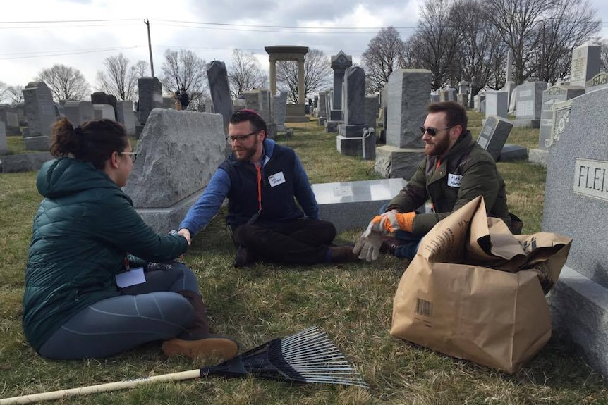 Rabbi Joel Seltzer (c) and Allen Hornblum (r) greet a volunteer helping with the clean-up.