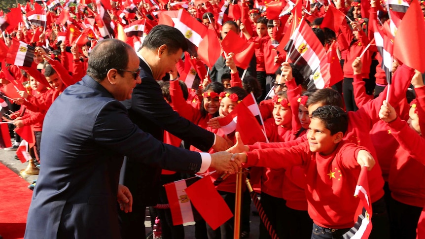 Egypt's President Abdel Fattah al-Sisi and China's President Xi Jinping shaking hands with children.